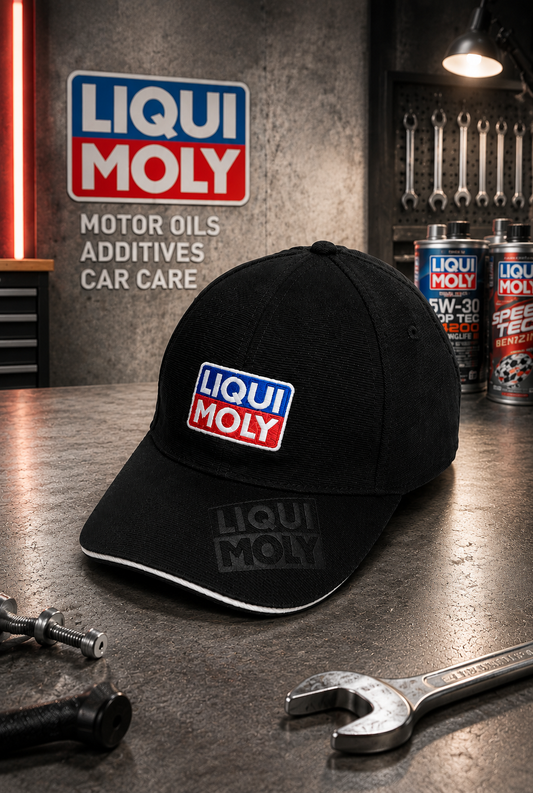 Schwarze Liqui Moly Cap mit gesticktem Logo auf einer Werkstattbank – im Hintergrund Liqui Moly Ölkanister und Werkzeug

